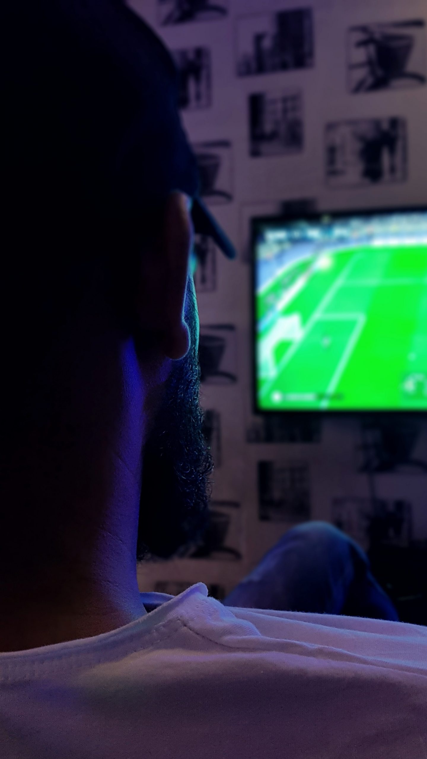 man watching football in the dark