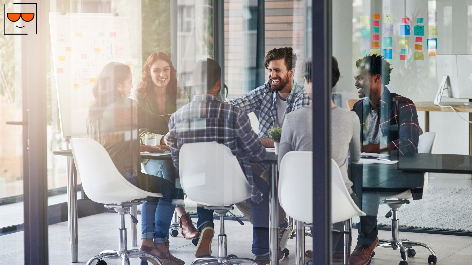 A group of people gathered in a conference room smiling and talking